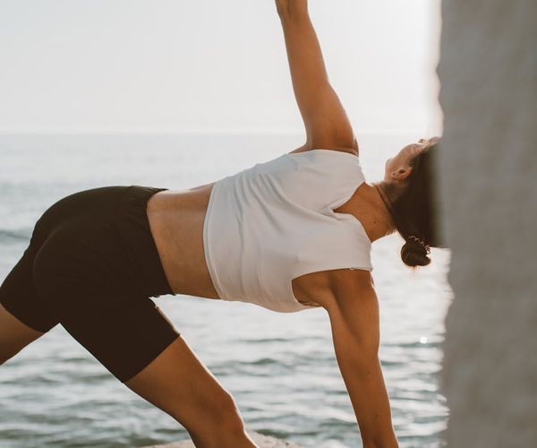 Silhouette of a person stretching during sunrise, symbolizing energy and vitality.
